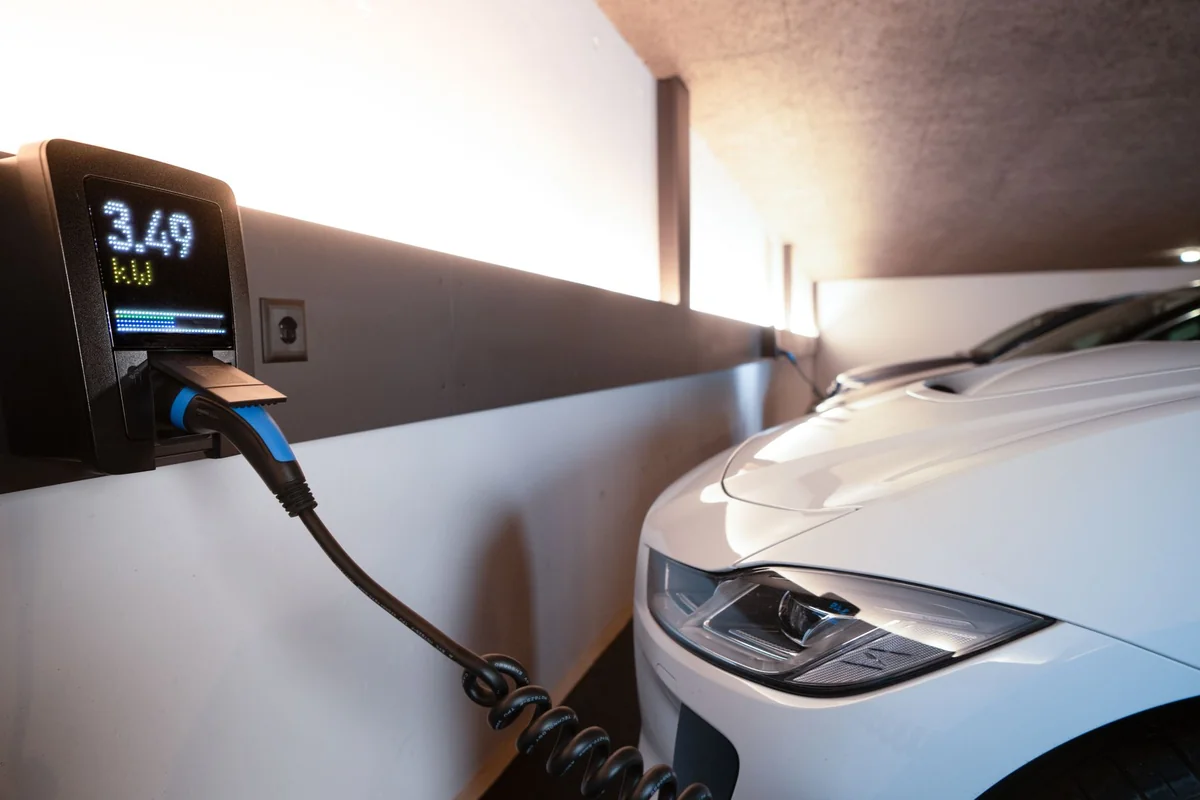 White electric car charging at indoor station, emphasizing sustainability and ef