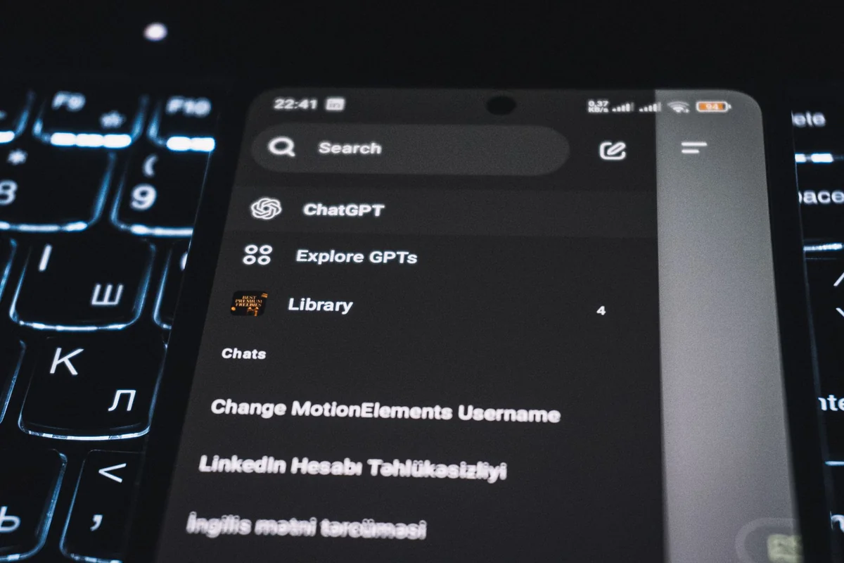 Close-up of a smartphone displaying a chat app interface with a backlit keyboard